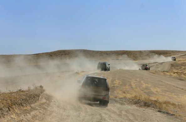 Kurdish Peshmerga vehicles escort media vehicles in an area they had retaken from the Islamic State, on Bashiqah mountain