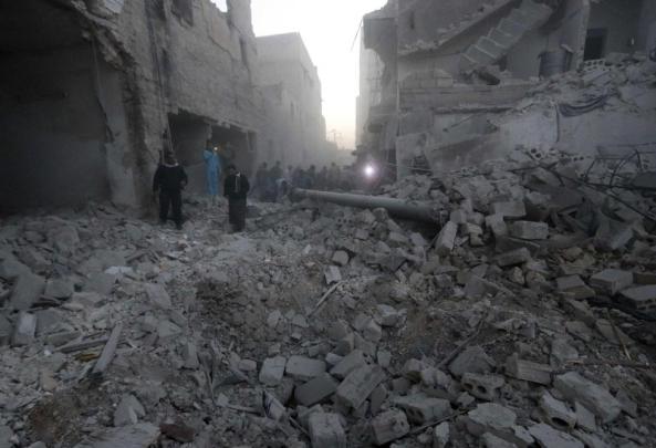 People inspect a site hit by what activists said was a barrel bomb dropped by forces loyal to Syria's President Bashar al-Assad on al-Marjeh neighborhood of Aleppo